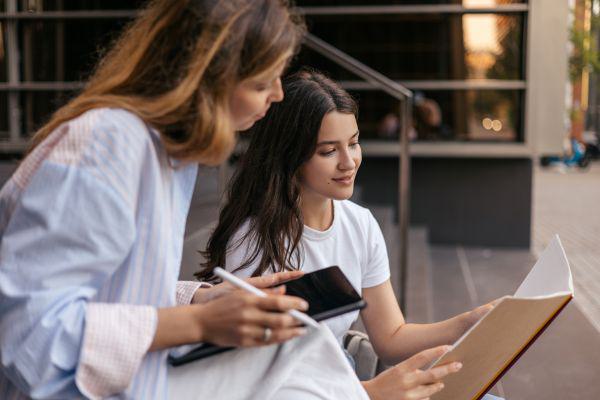 Etudiantes assises sur des marches consultant un dossier